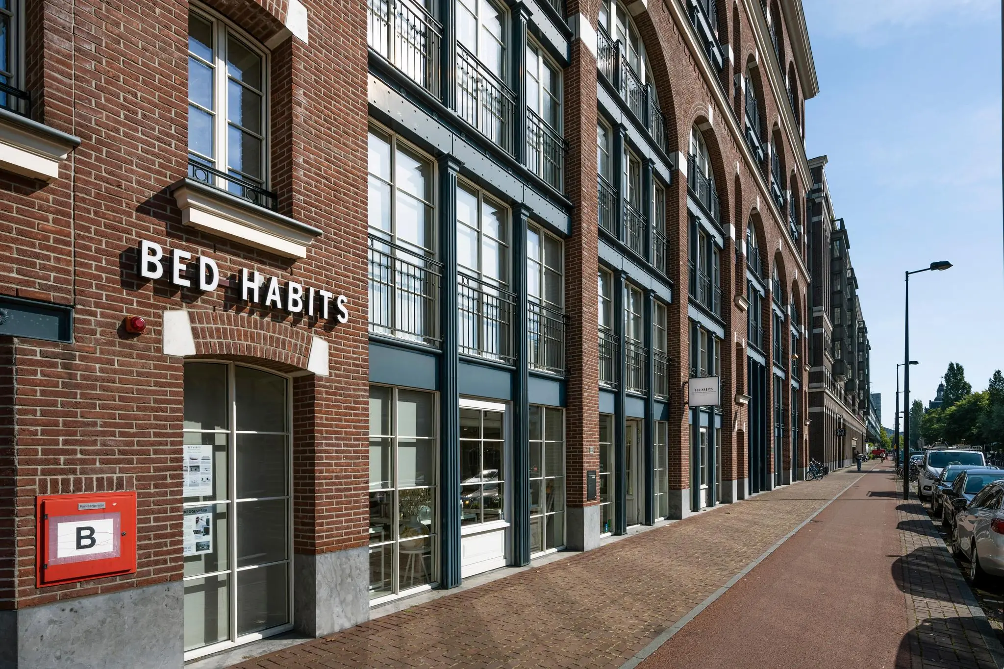 Gevel van het Bed Habits pand aan de Oostelijke Handelskade in Amsterdam met rode bakstenen en grote ramen.